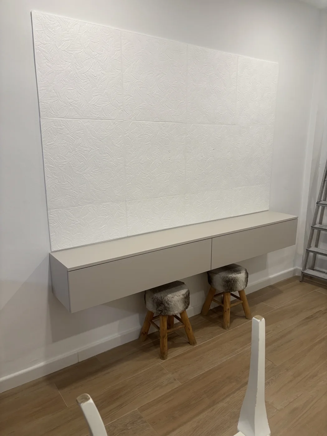 Detalle de panel decorativo blanco con textura sobre mueble suspendido